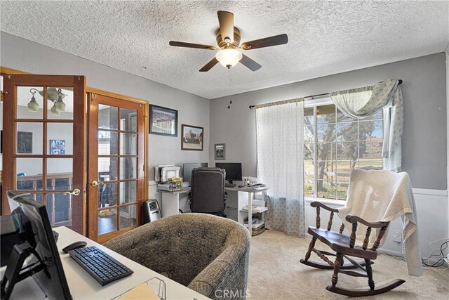 office area with a textured ceiling, ceiling fan, light colored carpet, and french doors