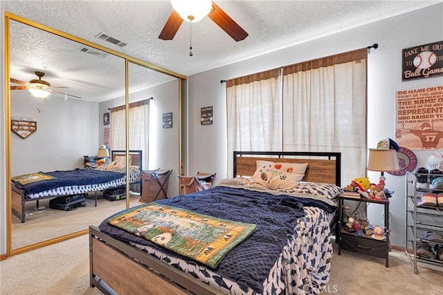 10187 Mesquite St, Oak Hills, CA 92344 - carpeted bedroom featuring a textured ceiling, multiple windows, ceiling fan, and a closet
