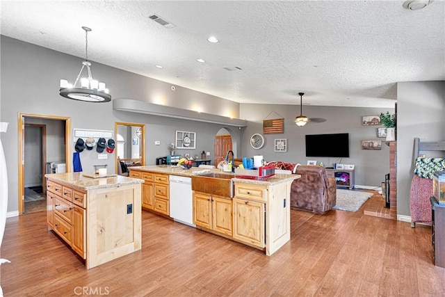 10187 Mesquite St, Oak Hills, CA 92344 - kitchen with white dishwasher, light brown cabinets, open floor plan, an island with sink, and a textured ceiling