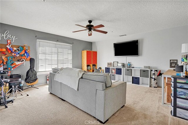 living room with ceiling fan, carpet, and a textured ceiling