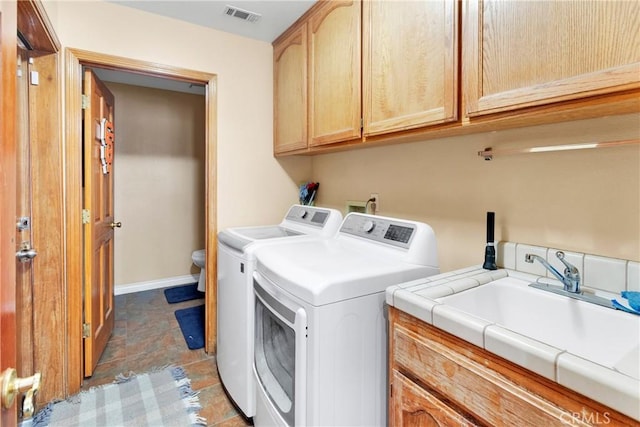 laundry room featuring sink, independent washer and dryer, and cabinets