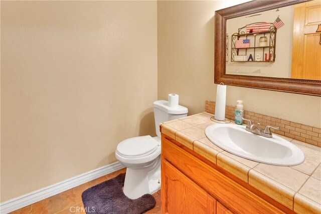 bathroom with toilet, tile patterned floors, and vanity