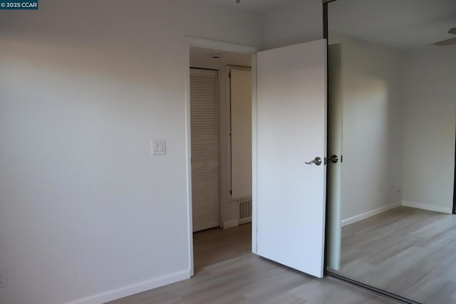 unfurnished bedroom featuring light hardwood / wood-style floors and a closet