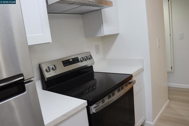 kitchen with white cabinets, light hardwood / wood-style floors, and stainless steel appliances