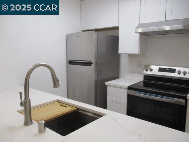 kitchen featuring sink, white cabinetry, and stainless steel appliances