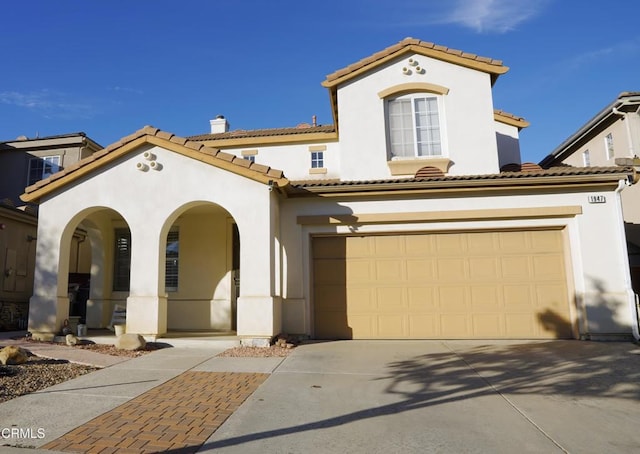 mediterranean / spanish home featuring covered porch and a garage