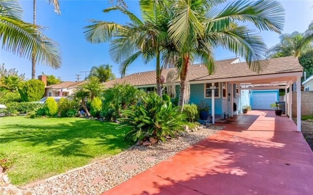 view of front of property featuring a front yard, a garage, and a carport