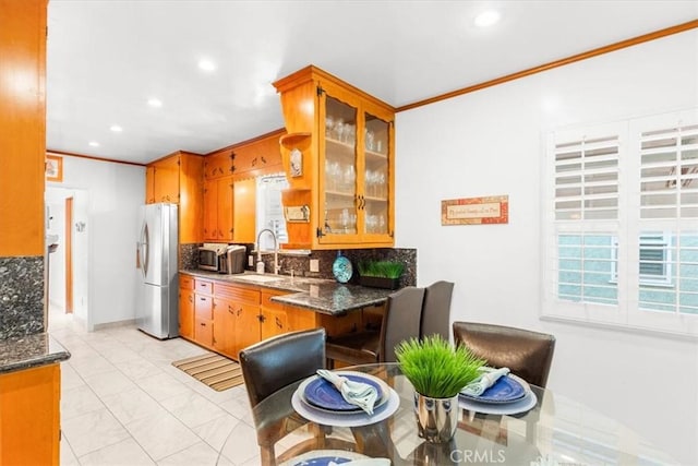 kitchen featuring sink, appliances with stainless steel finishes, crown molding, and tasteful backsplash