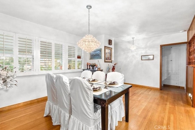 dining space featuring light hardwood / wood-style flooring and a notable chandelier