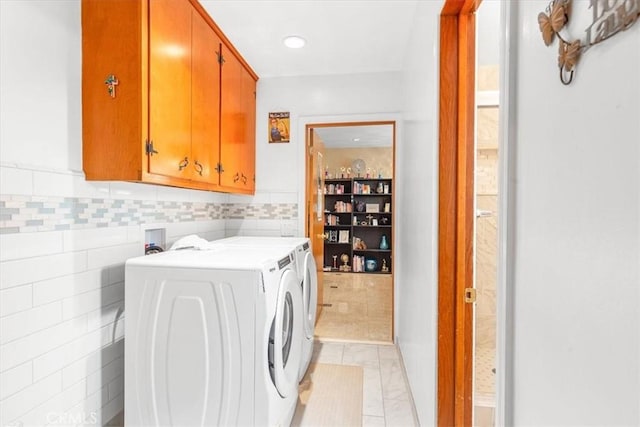 laundry area featuring washing machine and dryer and cabinets