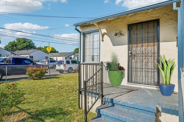 doorway to property with a lawn