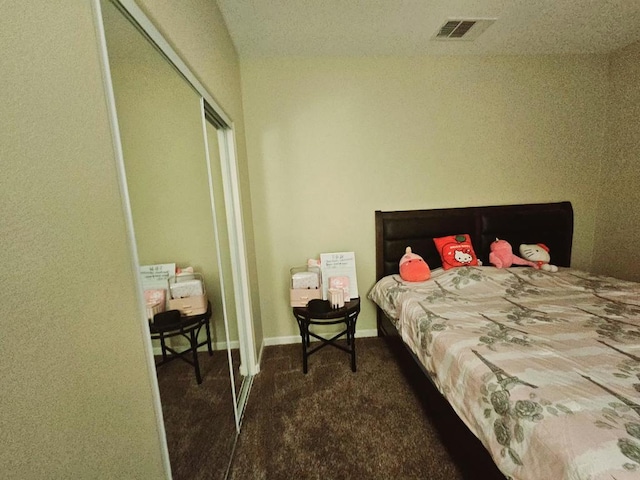 bedroom with a closet and dark colored carpet