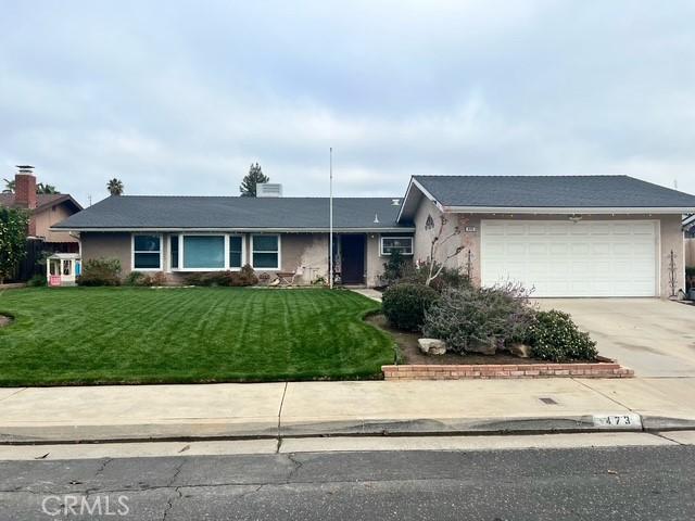 ranch-style home with a garage and a front lawn