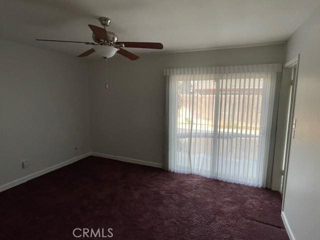 unfurnished room featuring ceiling fan and dark colored carpet