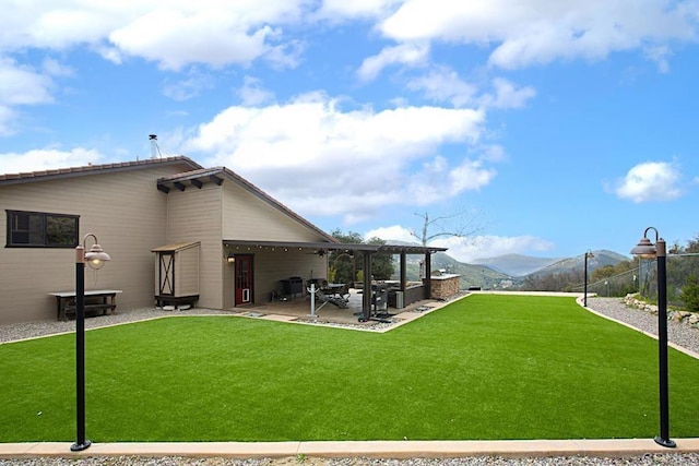 view of yard with a mountain view, a pergola, and a patio