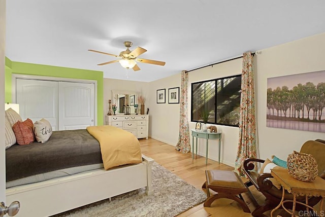 bedroom with light hardwood / wood-style flooring, a closet, and ceiling fan