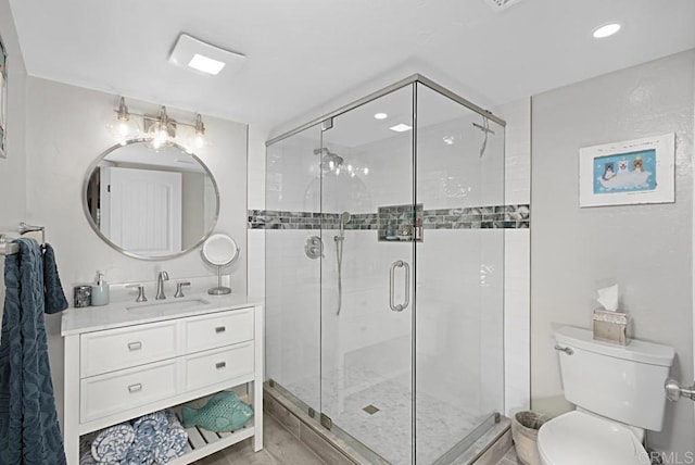 bathroom with vanity, toilet, and a shower with shower door