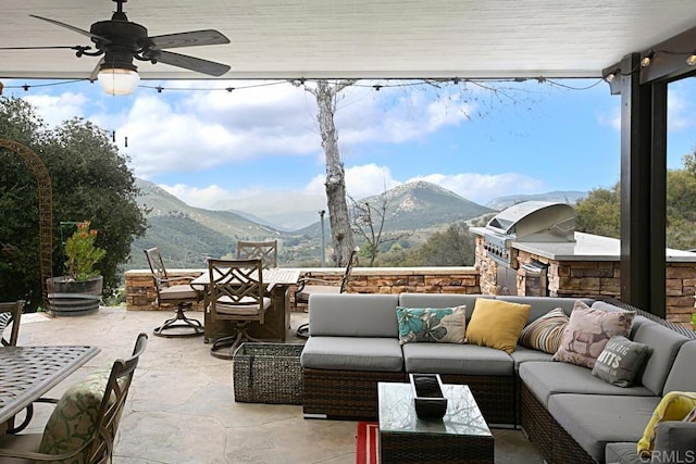 view of patio / terrace featuring a mountain view, an outdoor living space, grilling area, and ceiling fan