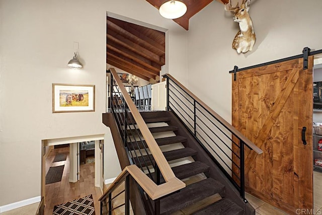 stairs featuring lofted ceiling, a barn door, and a chandelier