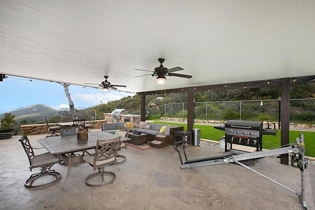 view of patio / terrace featuring area for grilling, a mountain view, an outdoor hangout area, and ceiling fan