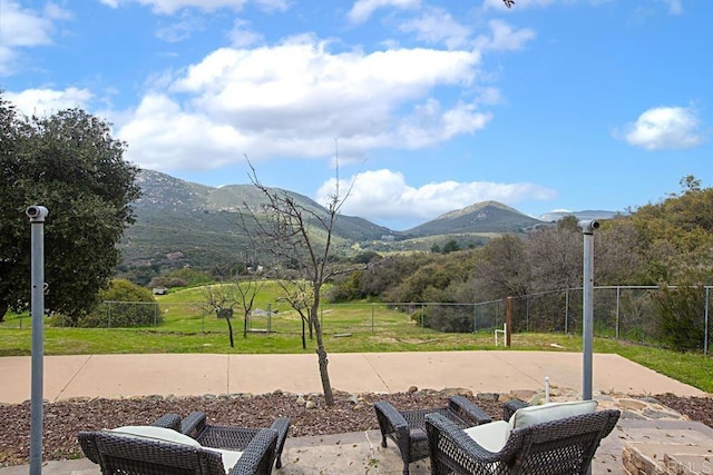 view of home's community with a patio, a mountain view, and a lawn