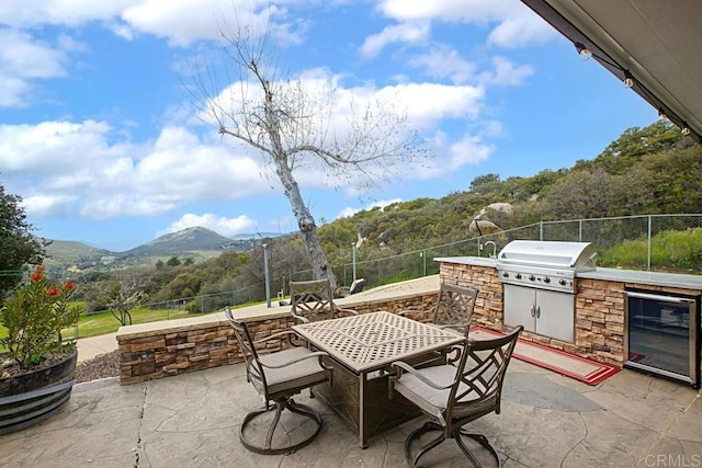 view of patio / terrace with an outdoor kitchen, grilling area, and a mountain view