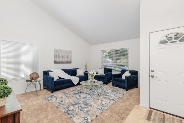 carpeted living room with high vaulted ceiling