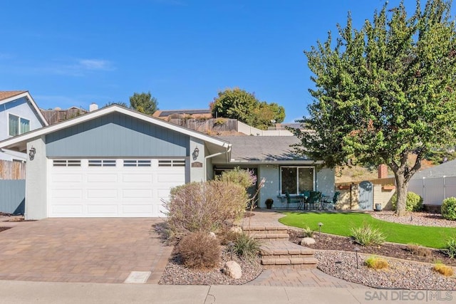 ranch-style house featuring a garage and a front lawn