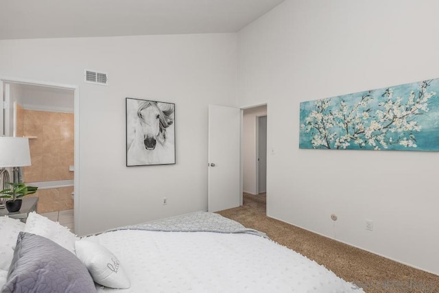 bedroom with connected bathroom, vaulted ceiling, and carpet