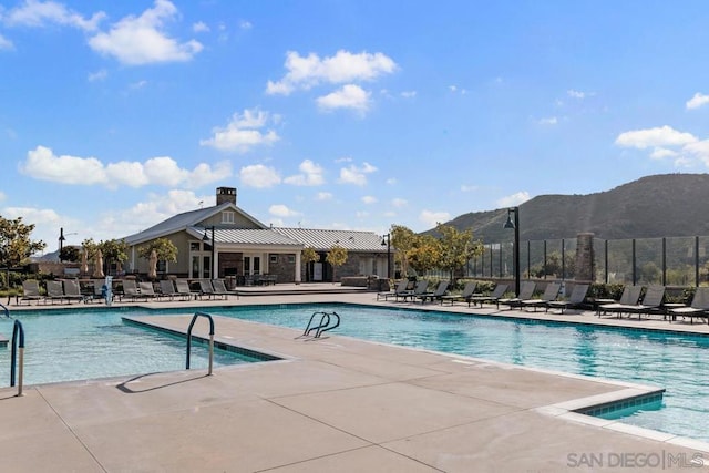 view of swimming pool featuring a patio area and a mountain view