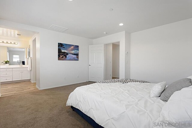 carpeted bedroom featuring ensuite bath