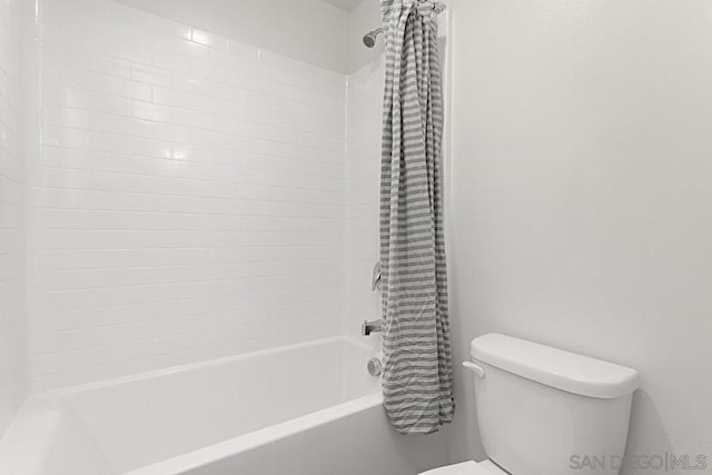 bathroom featuring toilet and shower / tub combo with curtain