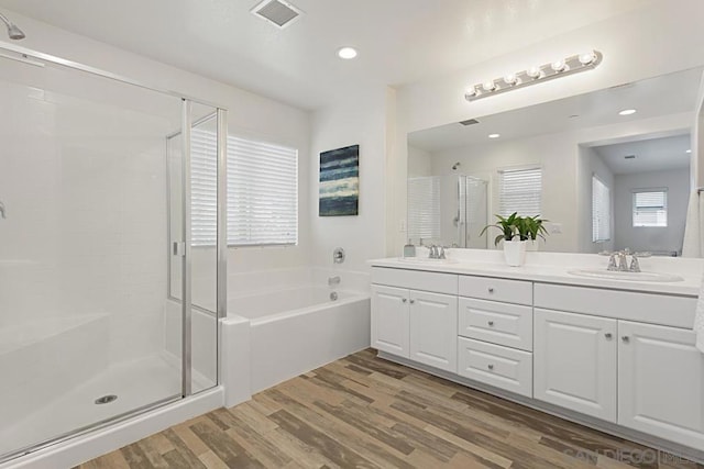 bathroom featuring plenty of natural light, shower with separate bathtub, wood-type flooring, and vanity