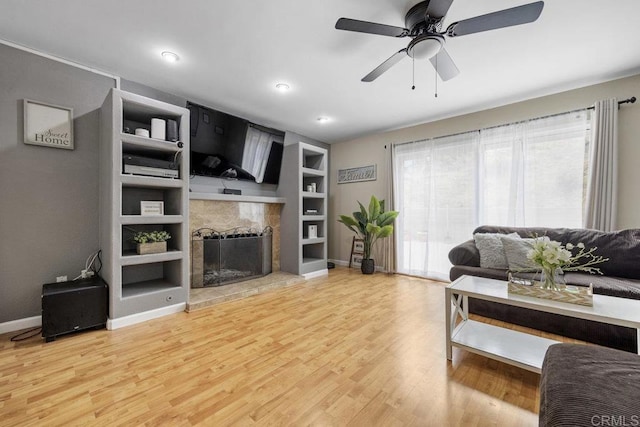 8115 Cacus, Spring Valley, CA 91977 - living area featuring a fireplace with raised hearth, built in shelves, light wood finished floors, ceiling fan, and recessed lighting