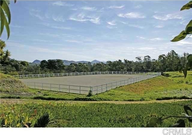 view of sport court featuring an enclosed area and a rural view