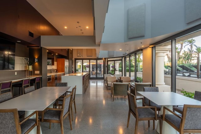 dining space with sink and a towering ceiling