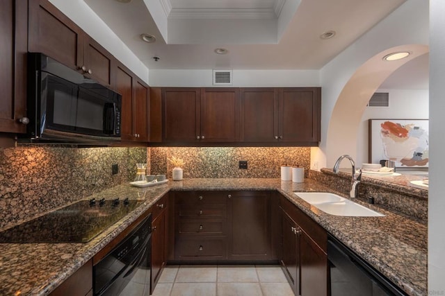 kitchen with black appliances, dark stone counters, sink, a tray ceiling, and crown molding