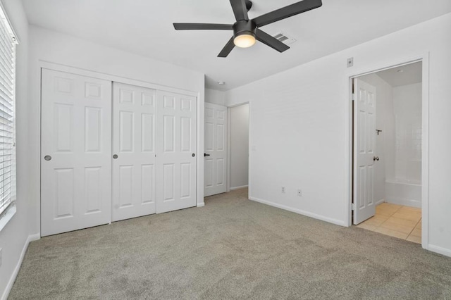 unfurnished bedroom with ceiling fan, connected bathroom, a closet, and light carpet