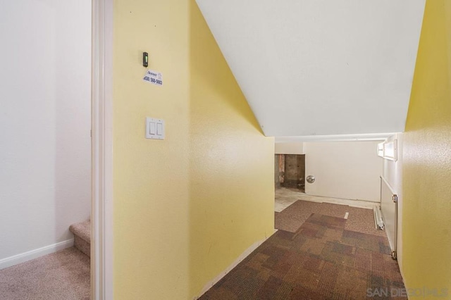 corridor featuring carpet and vaulted ceiling