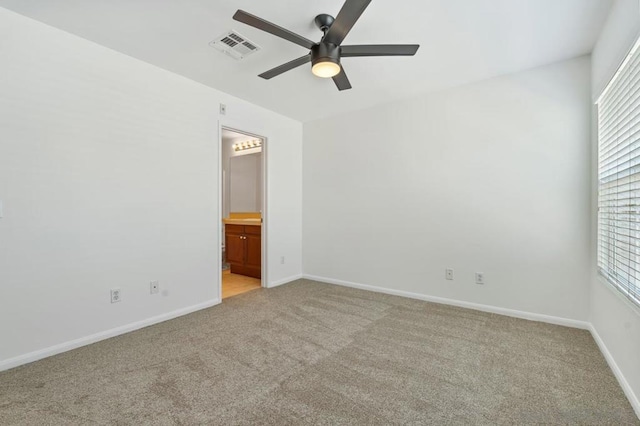 carpeted spare room featuring ceiling fan