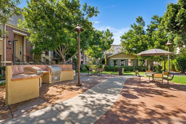 view of community with exterior kitchen and a patio