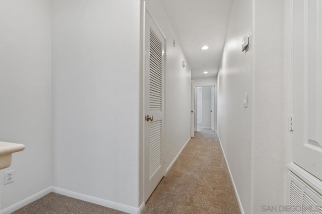 hall featuring light colored carpet