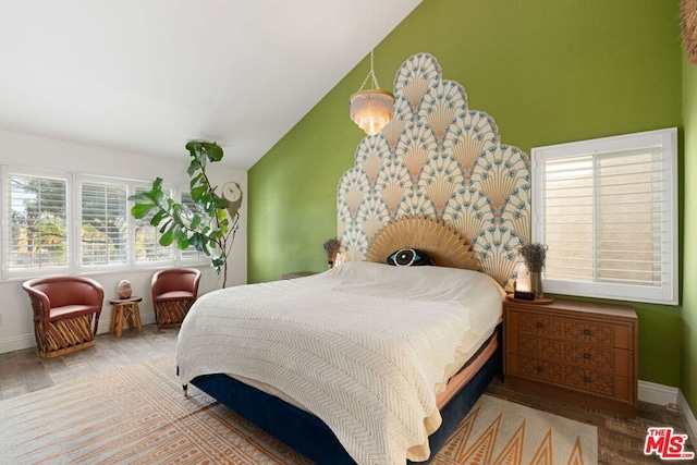 bedroom with vaulted ceiling and light hardwood / wood-style floors