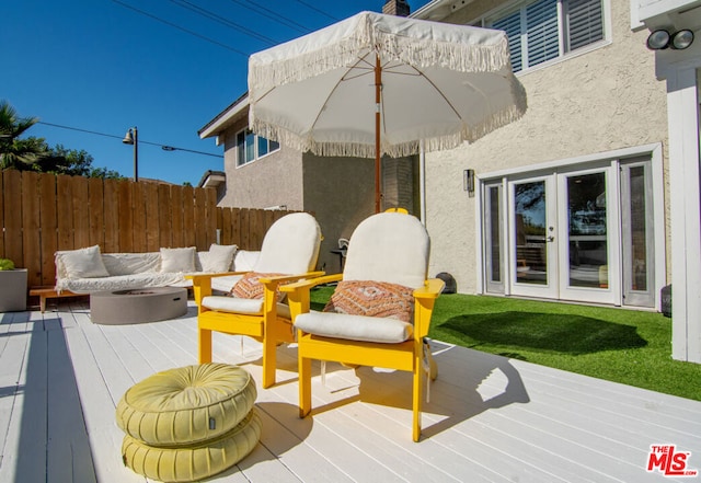 wooden deck featuring an outdoor fire pit and french doors