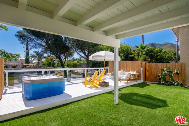 view of patio / terrace featuring an outdoor hangout area, a deck with mountain view, and a hot tub