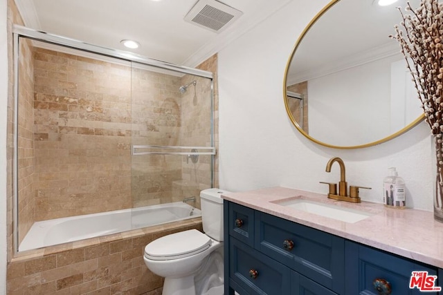 full bathroom featuring bath / shower combo with glass door, toilet, vanity, and crown molding