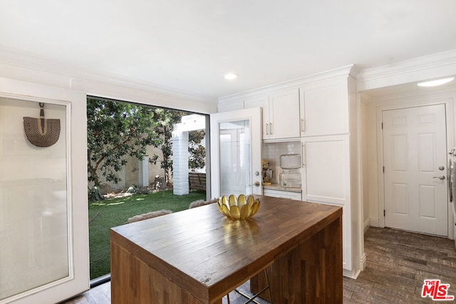 kitchen featuring dark wood-type flooring, white cabinets, tasteful backsplash, and a center island