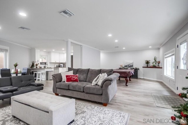 living room featuring light wood-type flooring, pool table, and ornamental molding