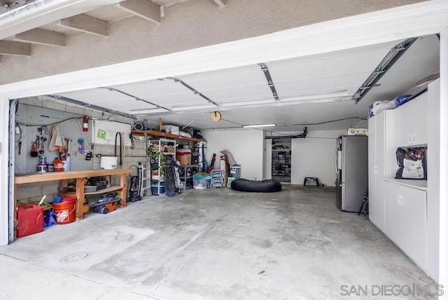 garage featuring a workshop area and stainless steel refrigerator