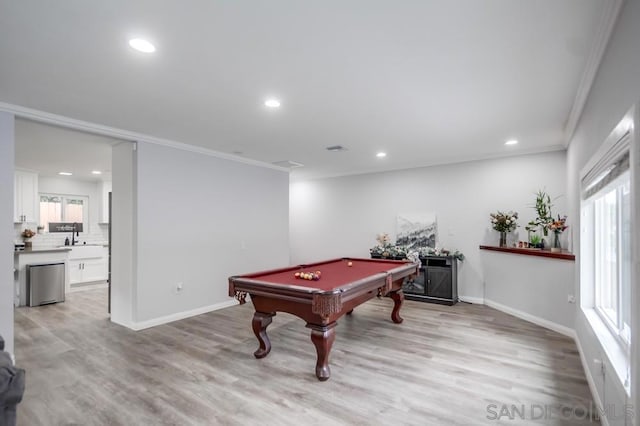 rec room with billiards, crown molding, and light wood-type flooring